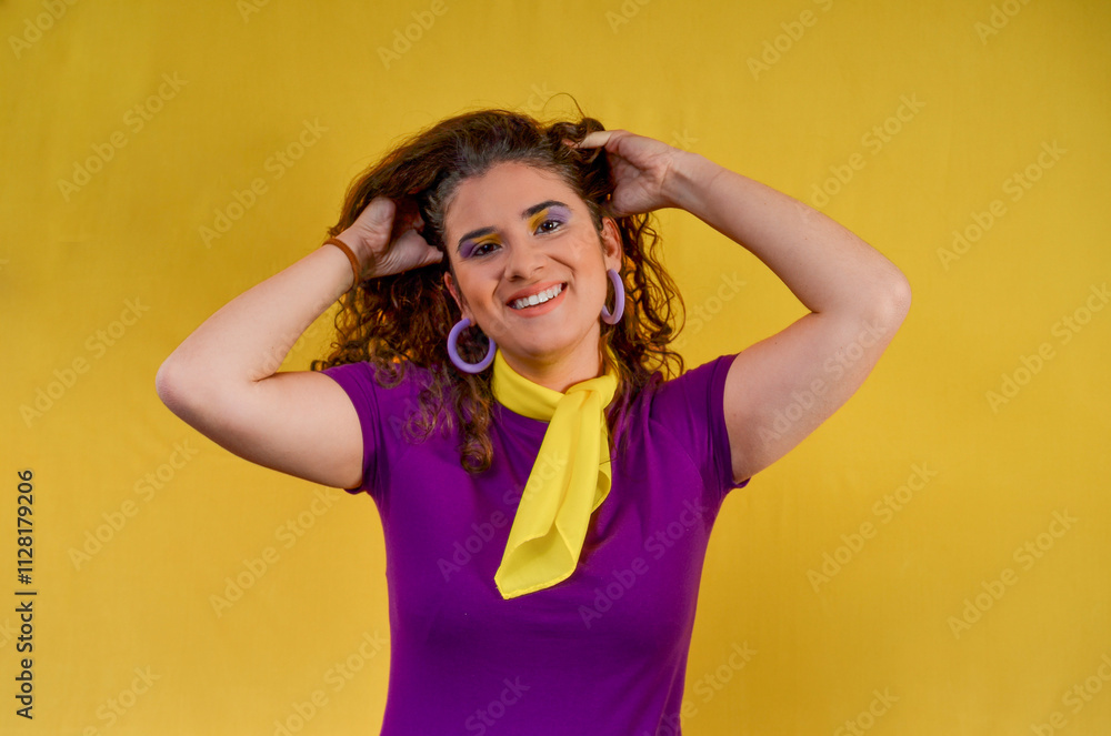 Young woman holding her hair smiling on yellow background Young woman holding her hair smiling on yellow background