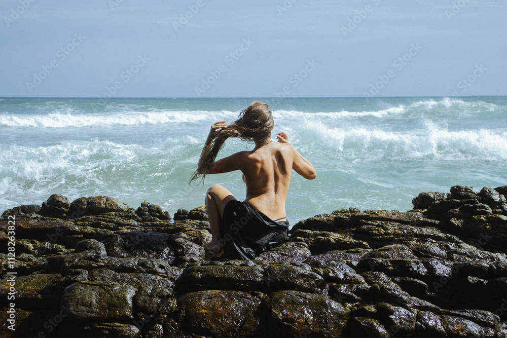 Woman on the rocks of a beach Woman on the rocks of a beach