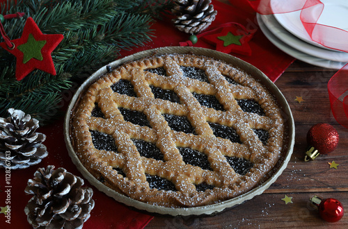 Crostata di Natale fatta in casa con marmellata di frutti di bosco su fondo di legno. Crostata Linzer, dolce austriaco. Stagione delle vacanze.