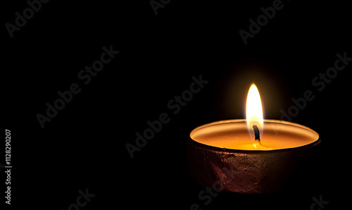 A lit candle in a dark setting, symbolizing warmth and tranquility.