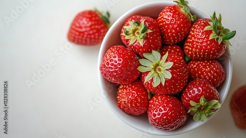 top down view of plain white ceramic bowl filled with fresh strawberries centered on clean white background
