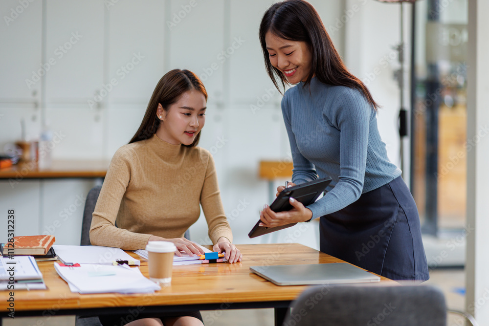 Fototapeta premium Two asian female creative agency casual meeting discussion working with laptop, analyze planning and financial statistics and investment market at office. 