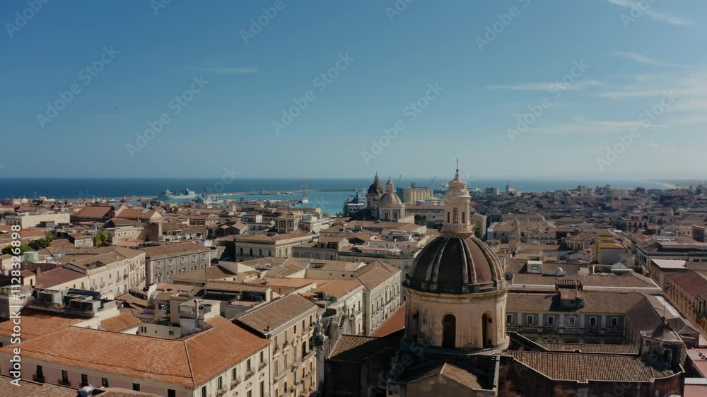 Cinematic orbit drone flight around San Michele Arcangelo ai Minoriti Cathedral in Catania with sea port in the background. Catania old town from above. Cinematic orbit drone flight around San Michele Arcangelo ai Minoriti Cathedral in Catania with sea port in the background. Catania old town from above.