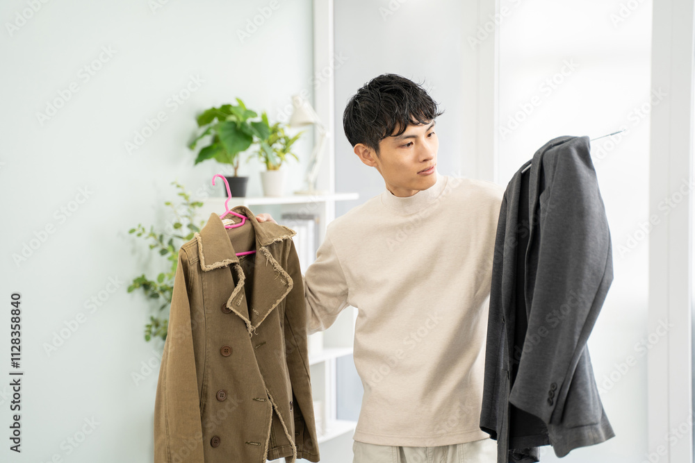 服を選ぶアジア人男性-白ベースのシンプルな部屋背景