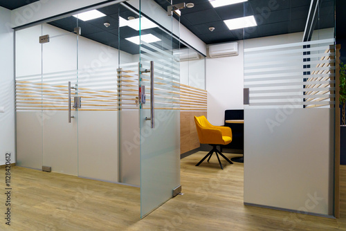 Modern office with glass partitions and stylish seating area