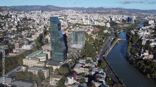 Wallpaper Mural Aerial orbits tall glass skyscraper by Kura River in downtown Tbilisi Torontodigital.ca