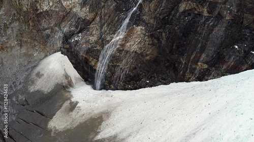 Waterfall drops into bergschrund crevasse of Adishi Glacier in Georgia