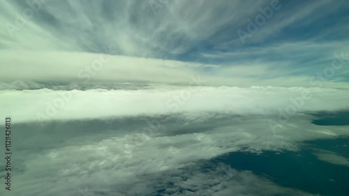 A pilot’s perspective POV FPV flying through a cold winter sky full of frayed and fluffy ethereal stratus clouds as seen by the pilots of a jet from the cockpit of a jet flying at cruise. 4K photo