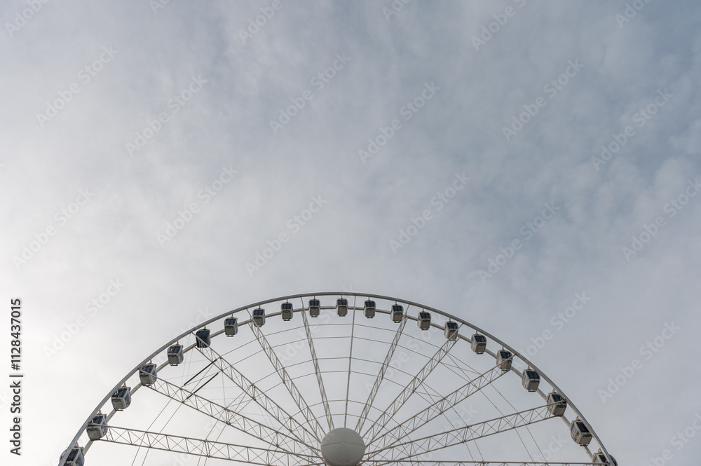 Wheel of Manchester. Majestic Ferris Wheel Under a Vast Cloudy Sky on a Clear Day Wheel of Manchester. Majestic Ferris Wheel Under a Vast Cloudy Sky on a Clear Day