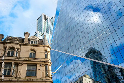 This image captures the reflection of skyscrapers on a historical building, highlighting the blend of contemporary design with classic architecture elements in London UK photo