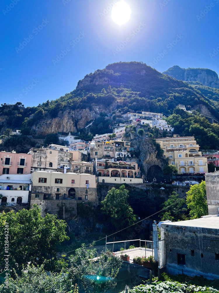 Obraz premium Charming Italian hillside village with vibrant sunlight and clear sky. Positano, Italy.