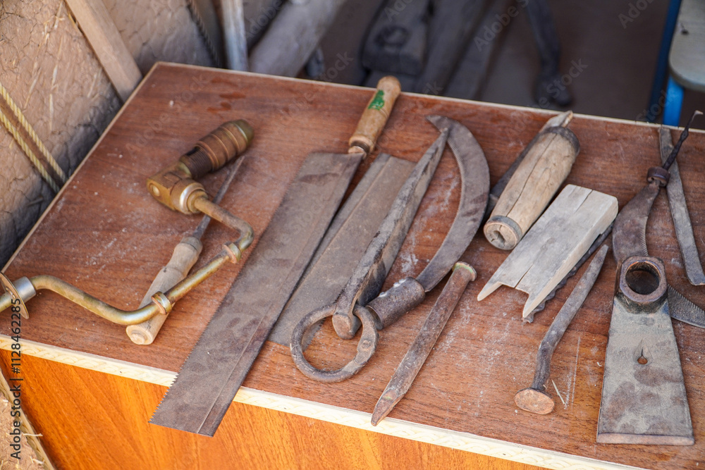 A variety of antique tools on a wooden table, showing signs of age and use. A glimpse into the past. Antique Carpentry Tools Collection. A variety of antique tools on a wooden table, showing signs of age and use. A glimpse into the past. Antique Carpentry Tools Collection.