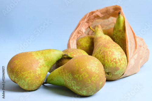 Fruit, conference pear on blue background and kraft paper bag photo