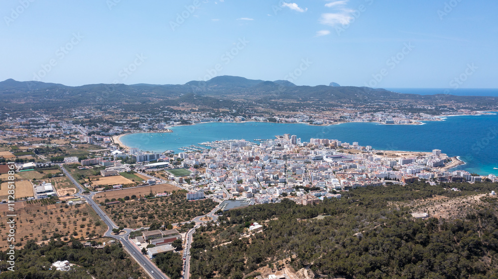 Aerial drone photo of a beach in the town of Sant Antoni de Portmany on the island of Ibiza in the Balearic Islands Spain showing the boating harbour and the beach known as Playa de San Antonio