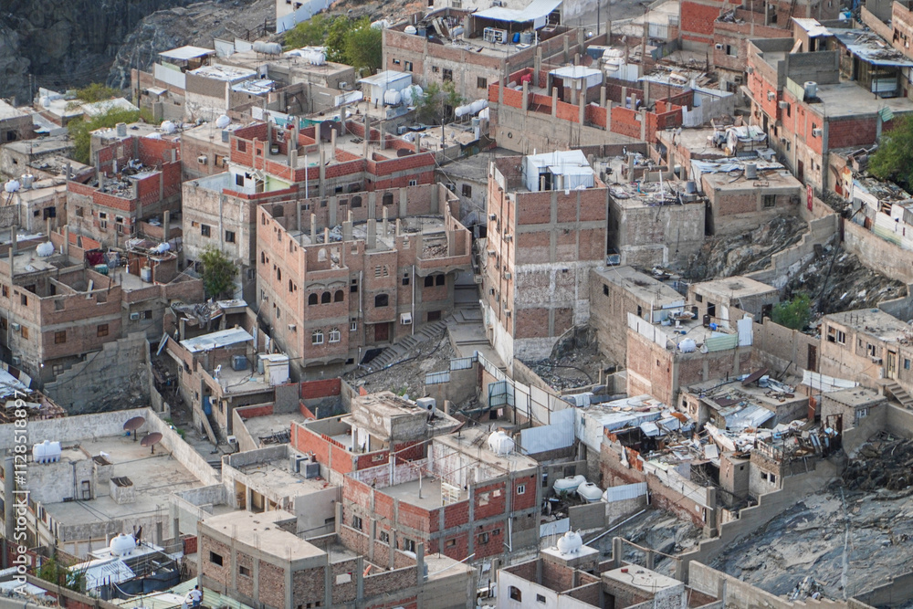 An aerial shot capturing a densely packed neighborhood clinging to a mountainside. Buildings are closely clustered together. Aerial View of a Densely Populated Mountainside Neighborhood. An aerial shot capturing a densely packed neighborhood clinging to a mountainside. Buildings are closely clustered together. Aerial View of a Densely Populated Mountainside Neighborhood.