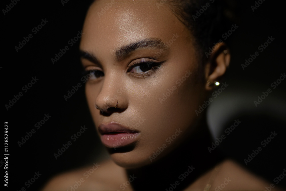 a close-up portrait of beautiful african woman against a dark background with dramatic lighting a close-up portrait of beautiful african woman against a dark background with dramatic lighting