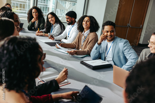 Diverse group of professionals in a seminar setting, engaging in lively discussion around a conference table photo