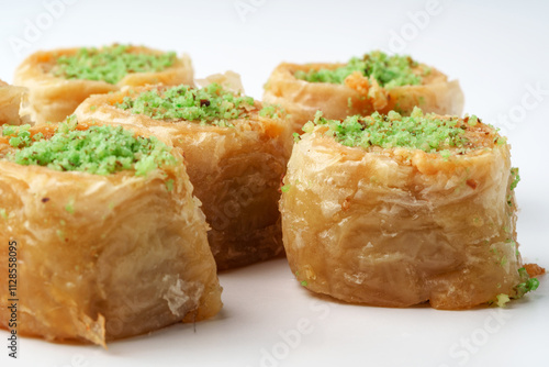 Delicious baklava rolls filled with pistachio and honey on a white background ready to be enjoyed photo