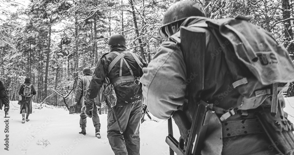 Heroes Of War. Re-enactors Dressed As American Infantry Soldier Marching Through Forest Road In Cold Winter Day. Group Of Usa Soldiers Marching Country Road. Usa Army Soldiers Of World War Ii Heroes Of War. Re-enactors Dressed As American Infantry Soldier Marching Through Forest Road In Cold Winter Day. Group Of Usa Soldiers Marching Country Road. Usa Army Soldiers Of World War Ii