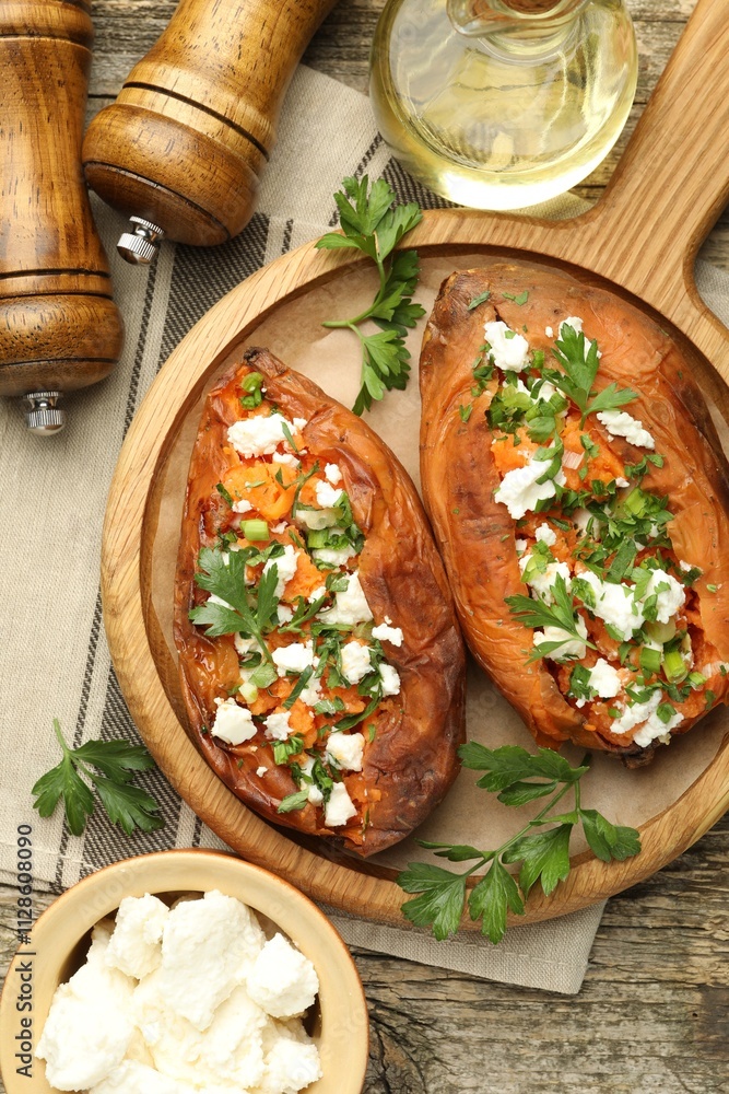 Tasty cooked sweet potatoes with feta cheese, green onion, parsley and oil on wooden board, flat lay Tasty cooked sweet potatoes with feta cheese, green onion, parsley and oil on wooden board, flat lay