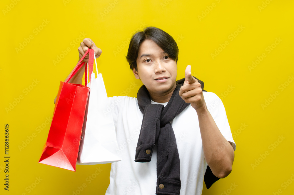 Happy Surprised Young Asian Man Holding Shopping Bags in Excitement Happy Surprised Young Asian Man Holding Shopping Bags in Excitement