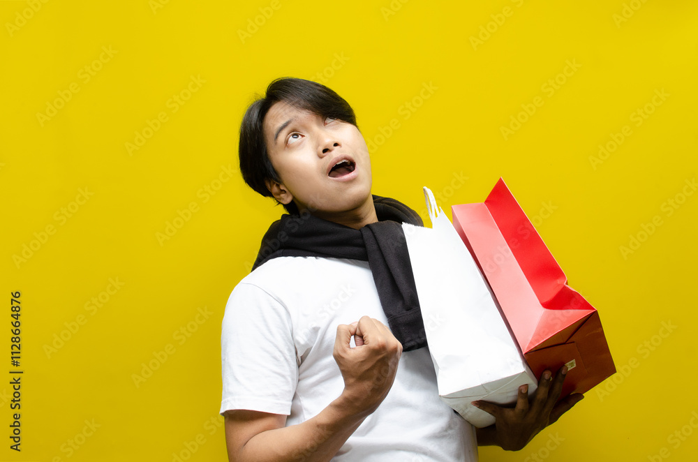 Side view of Happy Surprised Young Asian Man Holding Shopping Bags in Excitement Side view of Happy Surprised Young Asian Man Holding Shopping Bags in Excitement