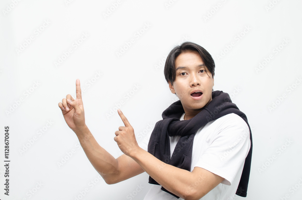 Young Asian Man in Casual Outfit Pointing to Copy Space for Advertising Concept Young Asian Man in Casual Outfit Pointing to Copy Space for Advertising Concept