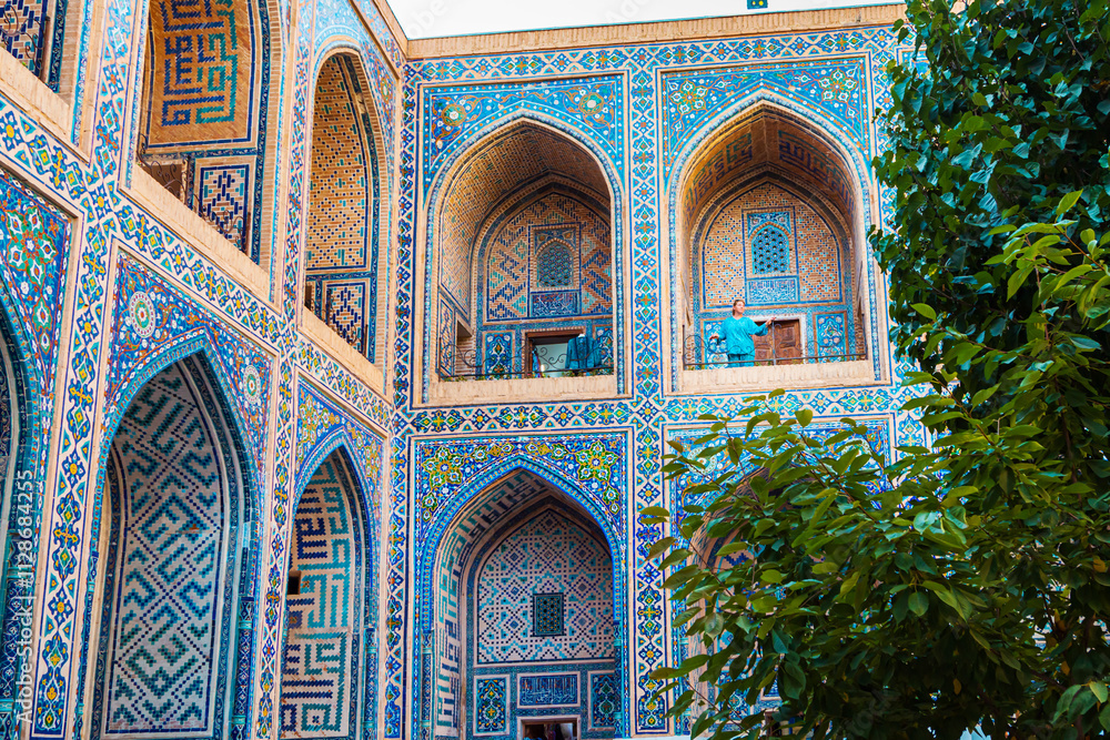 Obraz premium Woman in blue traditional clothing in the courtyard of the Ulugbek Madrassah.
