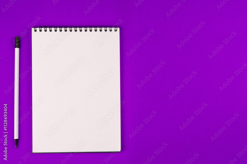 A notebook with an even spring at the top with white pages and a white pencil with a gray lead and a black eraser lie on a purple background on the left with space for text. High quality photo A notebook with an even spring at the top with white pages and a white pencil with a gray lead and a black eraser lie on a purple background on the left with space for text. High quality photo