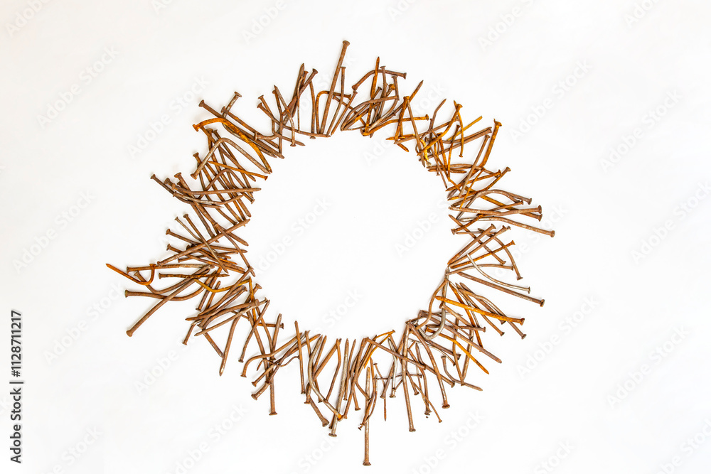 Fototapeta premium Round frame made of rusty bent nails on white background