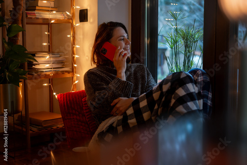 Obraz na płótnie Young Caucasian woman sitting comfortably at home talking on the phone during winter Christmas holidays w salonie