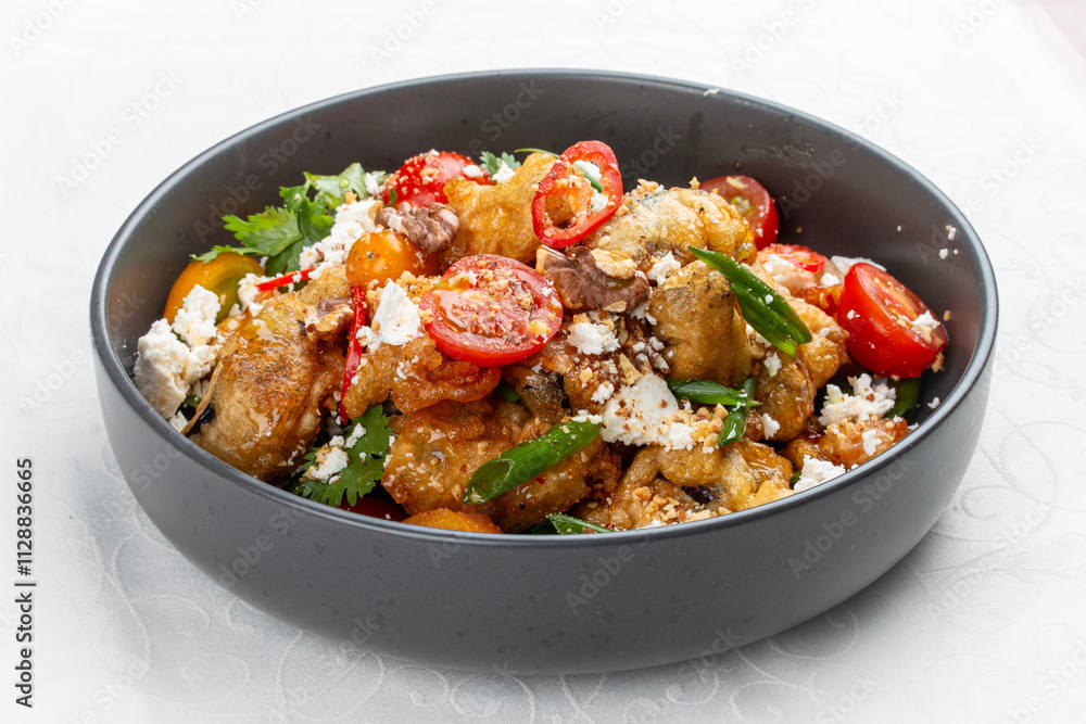 A vibrant salad featuring tempura-battered eggplant, juicy tomatoes, crunchy nuts, crumbled bryndza cheese, and fresh cilantro. A vibrant salad featuring tempura-battered eggplant, juicy tomatoes, crunchy nuts, crumbled bryndza cheese, and fresh cilantro.