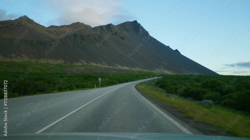 Vehicle drives along highway located near mountains Vehicle drives along highway located near mountains