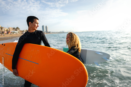 Photography Two young people, friends with surfboard going for surfing in the sea