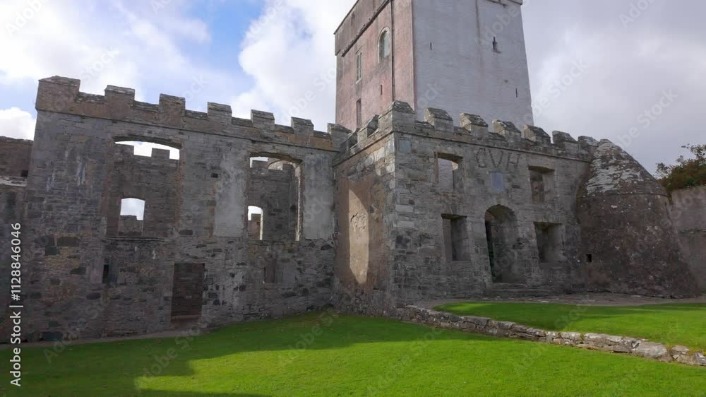 Doe Castle in Donegal Ireland - A breathtakingly magnificent view of a historic castle tower with its stone wall standing under a clear blue sky Doe Castle in Donegal Ireland - A breathtakingly magnificent view of a historic castle tower with its stone wall standing under a clear blue sky