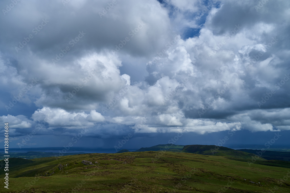 Cumulus or cluster clouds moving over a field with blue sky background in sunny weather in a wide angle shot Cumulus or cluster clouds moving over a field with blue sky background in sunny weather in a wide angle shot