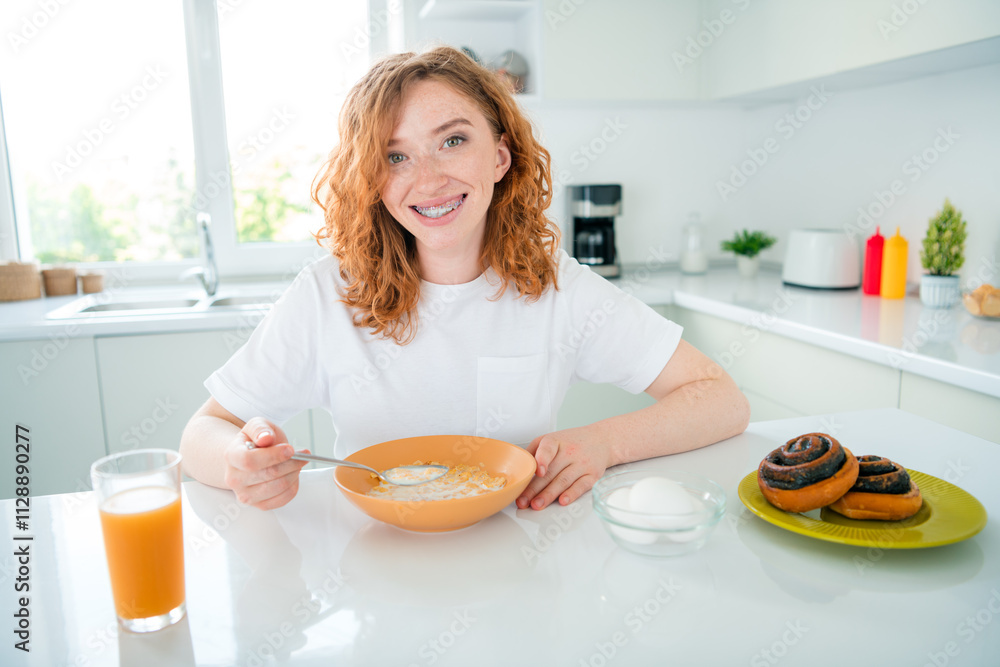 Young woman enjoying a delightful homemade breakfast in a bright kitchen Young woman enjoying a delightful homemade breakfast in a bright kitchen