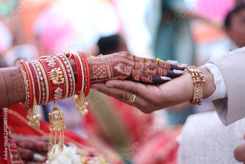 Forever Bound: A Close-up of hands adorned with intricate henna and traditional Indian bridal jewelry, symbolizing the sacred union of marriage. A tender moment captured in vibrant detail.  photo