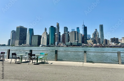 Picnic table at brooklyn along east river that can see midtown manhattan skyscraper skyline .