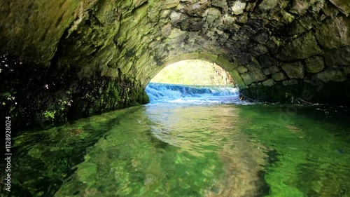 Footage from above to below of the Lathkill River flowing under a bridge near Lathkill Dale, England photo