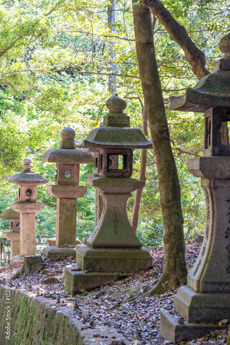 The walking paths through the sacred grove of Mount Inari are flanked by many stone lanterns in Kyoto, Japan