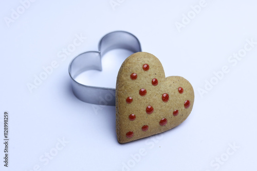 Gingerbread heart and cookie cutter on white background. Valentine's day concept.