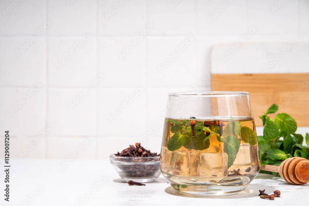 Clove mint julep summer infused drink, clove water or tea. Ayurvedic, antiseptic, anti-inflammatory and antioxidant drink, brewed dry clove remedy in glass Clove mint julep summer infused drink, clove water or tea. Ayurvedic, antiseptic, anti-inflammatory and antioxidant drink, brewed dry clove remedy in glass