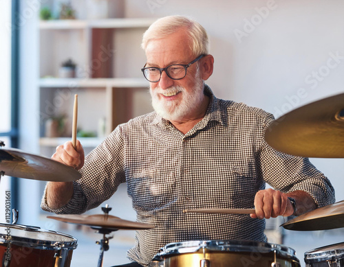 senior man learning to play the drums at her home