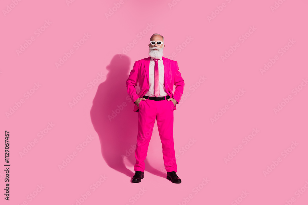 Full size photo of cool santa claus male hands pockets confident posing dressed sunglass pink suit isolated pastel background Full size photo of cool santa claus male hands pockets confident posing dressed sunglass pink suit isolated pastel background