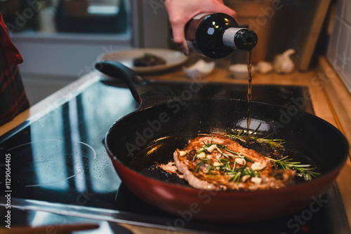 Mann brät sich ein Stück Fleisch zu Hause in der Pfanne photo