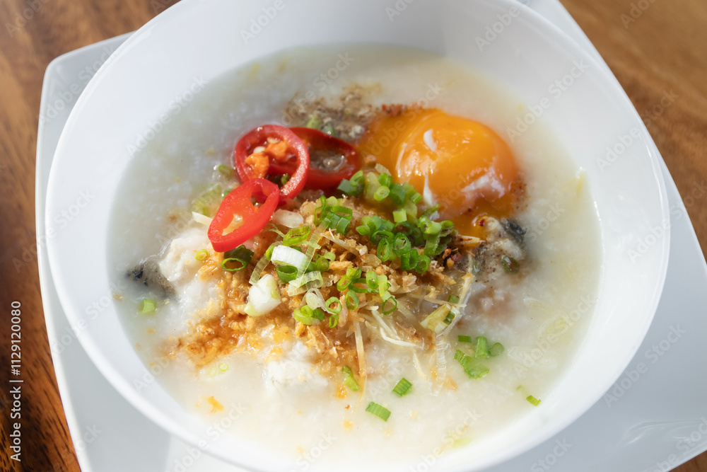Rice congee with soft-boiled egg flavor with pickled chili vinegar and ground dried chilies Rice congee with soft-boiled egg flavor with pickled chili vinegar and ground dried chilies