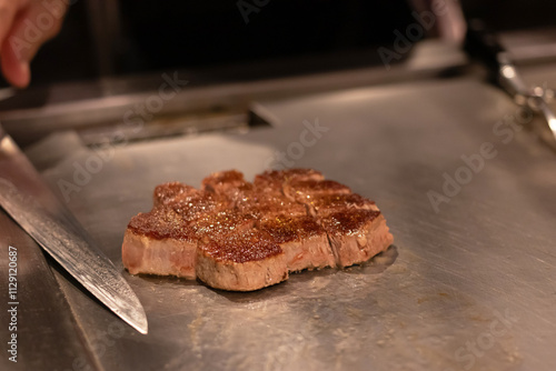 Chef cooking a delicious steak on the grill. photo