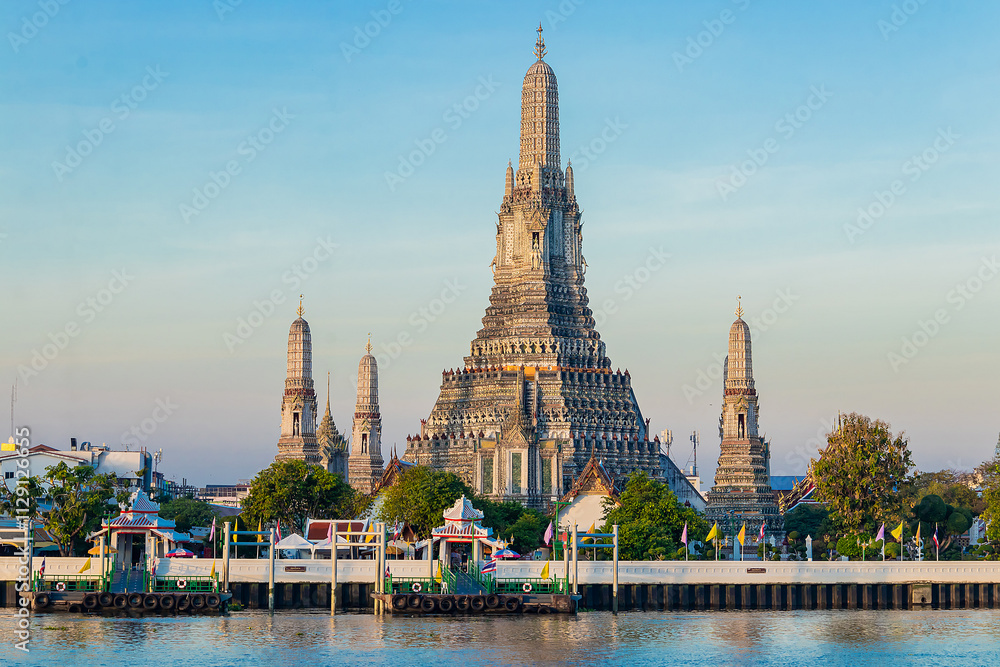 Fototapeta premium Beautiful of Buddhist temple or Wat Arun Ratchawararam Ratchawaramahawihan with famous tourist landmark sunlight in the morning, Bangkok, Thailand.