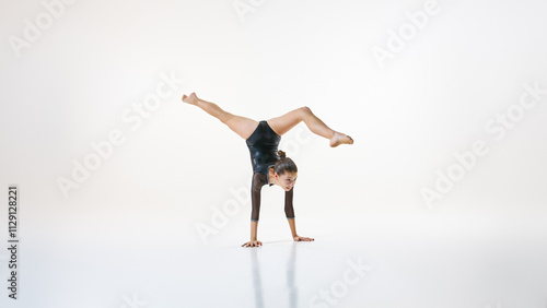 Wallpaper Mural Girl, gymnast focuses on controlled poses to enhance physical precision against white studio background. Copy space. Concept of professional sport, rhythm, elegance, movement. ad Torontodigital.ca